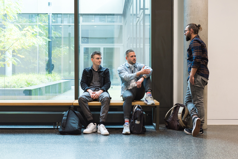 Drei Studierende unterhalten sich im Gang-Bereich der Magistrale, Campus Bielefeld